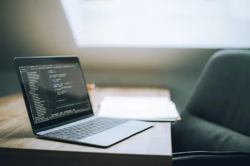 Ordinateur portable ouvert sur du code, dans un bureau lumineux